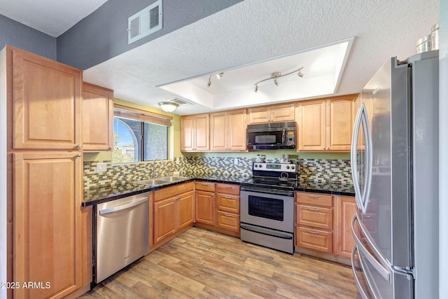 2524 S El Paradiso Dr Unit 82, Mesa, AZ 85202 - kitchen featuring appliances with stainless steel finishes, a sink, light wood-style floors, tasteful backsplash, and a textured ceiling