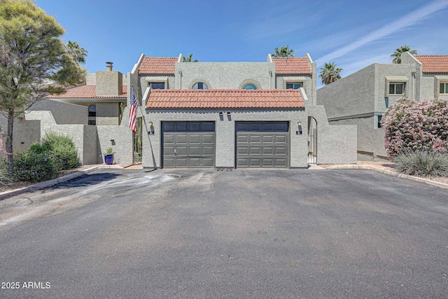 2524 S El Paradiso Dr Unit 82, Mesa, AZ 85202 - view of front of home featuring a garage, a tile roof, stucco siding, and asphalt driveway