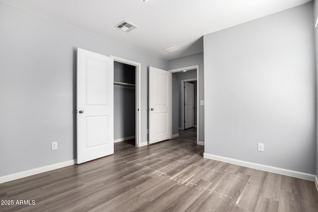 unfurnished bedroom featuring hardwood / wood-style flooring and a closet