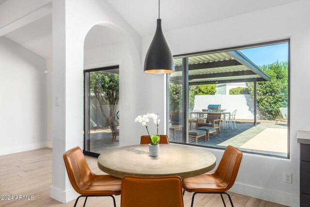 dining space featuring lofted ceiling and light hardwood / wood-style flooring