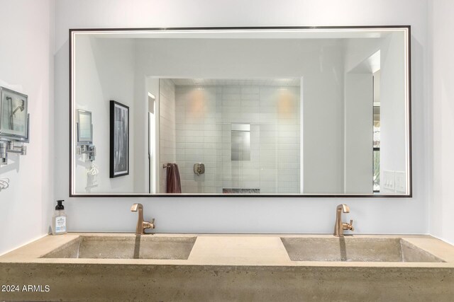 bathroom with tiled shower and vanity