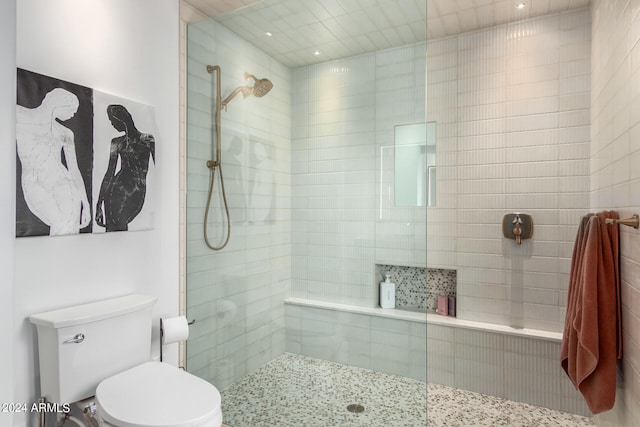 bathroom with tiled shower and toilet