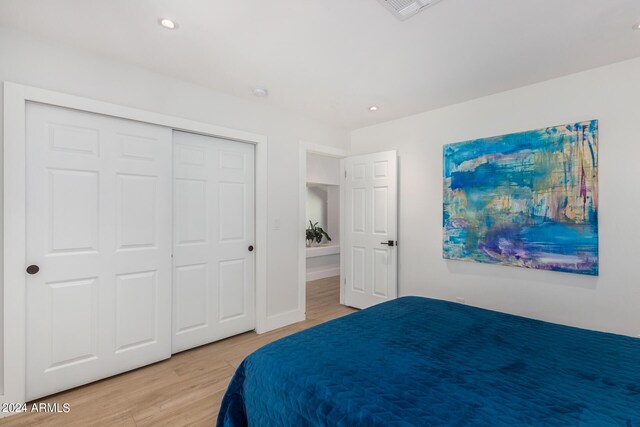 bedroom with a closet and light hardwood / wood-style floors