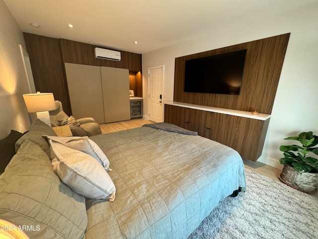 bedroom featuring light hardwood / wood-style floors and a wall mounted air conditioner