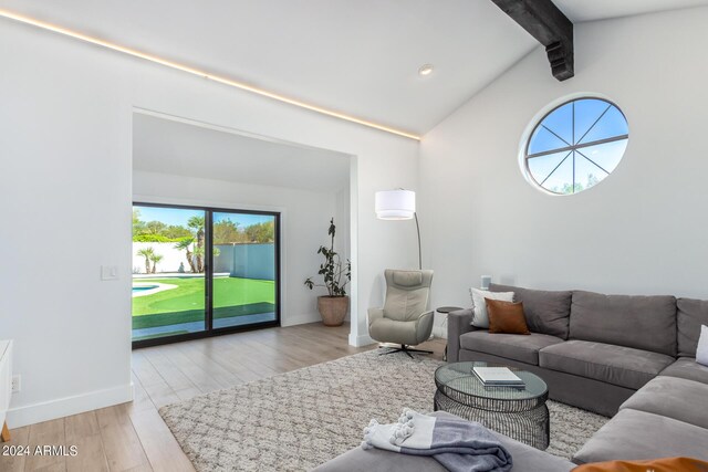 living room featuring light hardwood / wood-style floors and lofted ceiling with beams