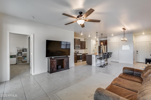 tiled living room featuring sink and ceiling fan