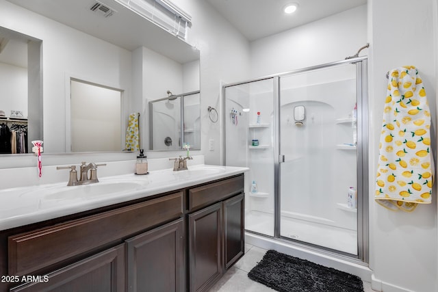 bathroom featuring tile patterned flooring, a shower with shower door, and vanity