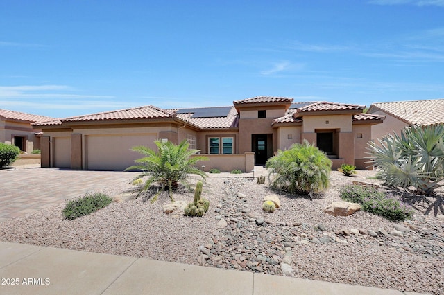 19745 N Mountain Sage Ln, Surprise, AZ 85374 - view of front facade featuring an attached garage, stucco siding, solar panels, driveway, and a tile roof