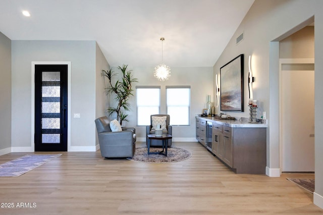 19745 N Mountain Sage Ln, Surprise, AZ 85374 - foyer entrance featuring light wood-style floors, a dry bar, beverage cooler, lofted ceiling, and a chandelier