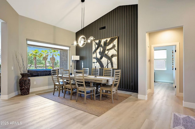 19745 N Mountain Sage Ln, Surprise, AZ 85374 - dining area featuring wood finished floors, a towering ceiling, and an accent wall