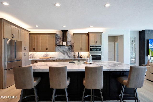 19745 N Mountain Sage Ln, Surprise, AZ 85374 - kitchen with stainless steel appliances, wall chimney exhaust hood, decorative backsplash, a spacious island, and a breakfast bar area