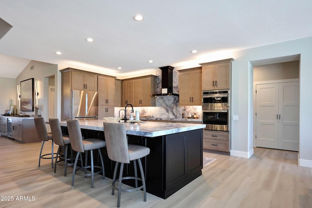19745 N Mountain Sage Ln, Surprise, AZ 85374 - kitchen featuring wall chimney exhaust hood, appliances with stainless steel finishes, tasteful backsplash, a kitchen bar, and a large island