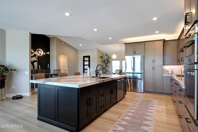 19745 N Mountain Sage Ln, Surprise, AZ 85374 - kitchen featuring stainless steel appliances, a kitchen island with sink, light wood-style flooring, recessed lighting, and light stone counters