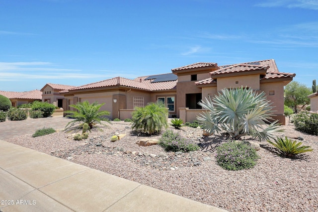 19745 N Mountain Sage Ln, Surprise, AZ 85374 - mediterranean / spanish home featuring stucco siding, an attached garage, roof mounted solar panels, a tiled roof, and driveway