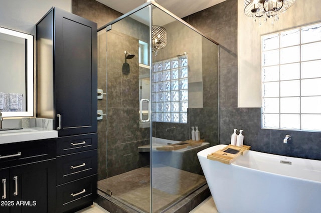 19745 N Mountain Sage Ln, Surprise, AZ 85374 - bathroom featuring a freestanding bath, a chandelier, a stall shower, vanity, and tile walls