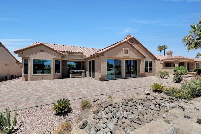 19745 N Mountain Sage Ln, Surprise, AZ 85374 - back of house featuring a hot tub, stucco siding, a patio, and a tiled roof