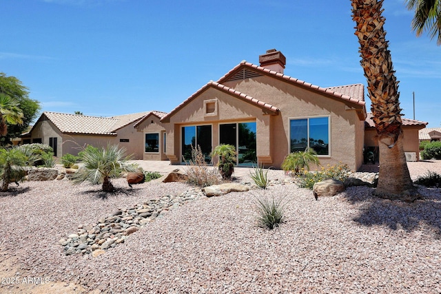 19745 N Mountain Sage Ln, Surprise, AZ 85374 - rear view of house featuring a chimney, stucco siding, and a tiled roof