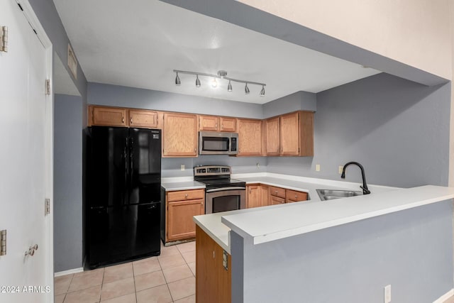 kitchen featuring light tile patterned floors, kitchen peninsula, sink, and appliances with stainless steel finishes