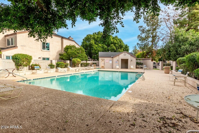 view of swimming pool with a patio area and an outbuilding