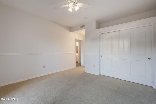 unfurnished bedroom with ceiling fan, light colored carpet, and a closet