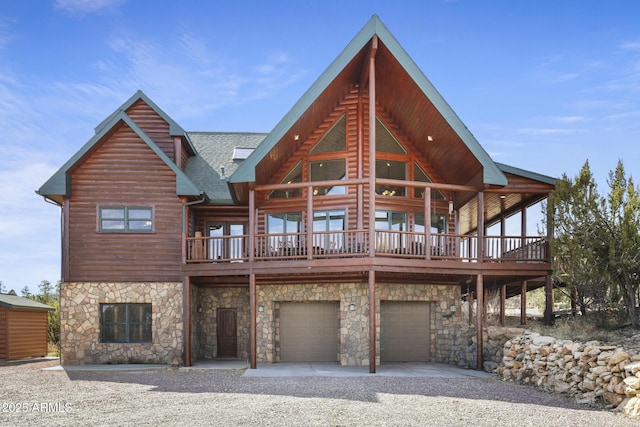 back of property featuring a wooden deck and a garage