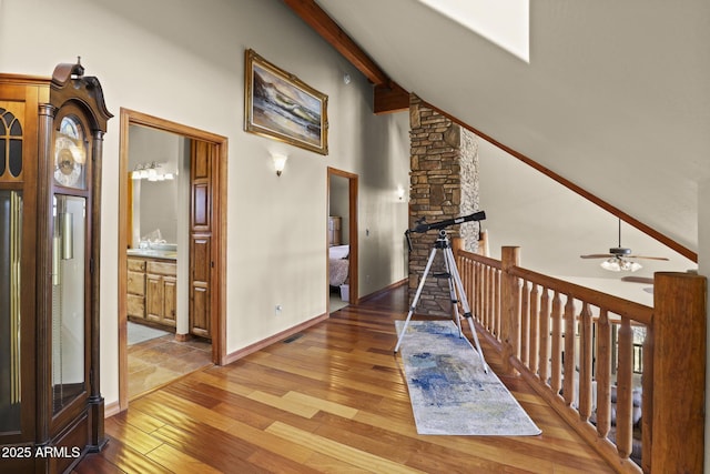 hallway with beamed ceiling, high vaulted ceiling, and hardwood / wood-style floors