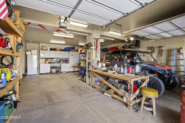 garage with white refrigerator, a garage door opener, and a workshop area