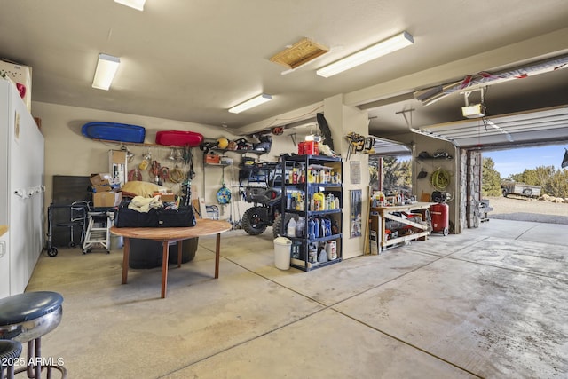 garage with a garage door opener and a workshop area