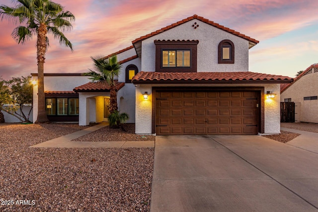 mediterranean / spanish-style home featuring concrete driveway and stucco siding