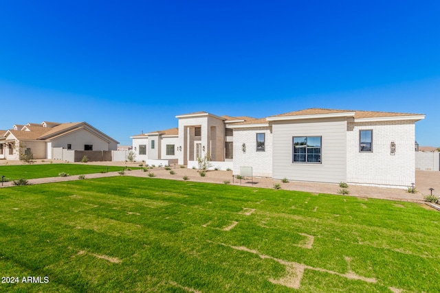 back of house with a patio and a lawn