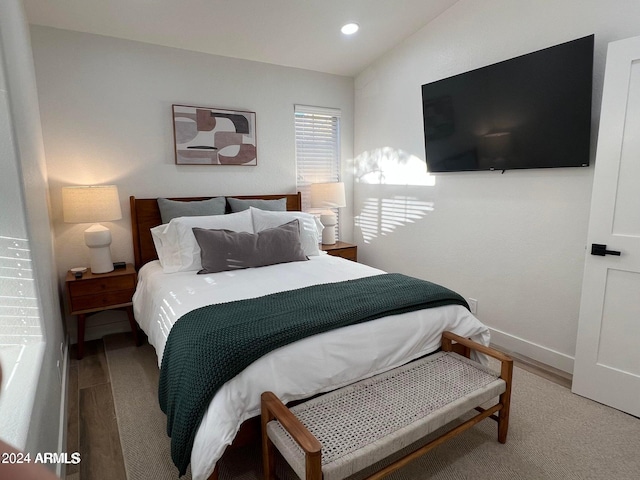 bedroom with lofted ceiling and wood-type flooring