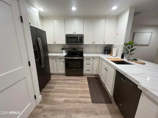 kitchen with white cabinetry and black appliances