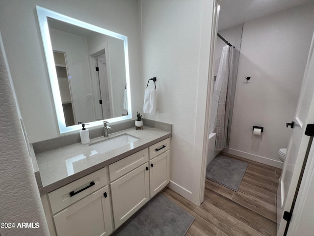 full bathroom with vanity, hardwood / wood-style flooring, toilet, and shower / tub combo with curtain