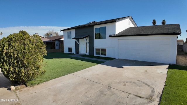 split foyer home with a garage, concrete driveway, a front yard, and stucco siding