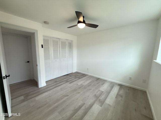 unfurnished bedroom with a closet, a ceiling fan, light wood-type flooring, and baseboards