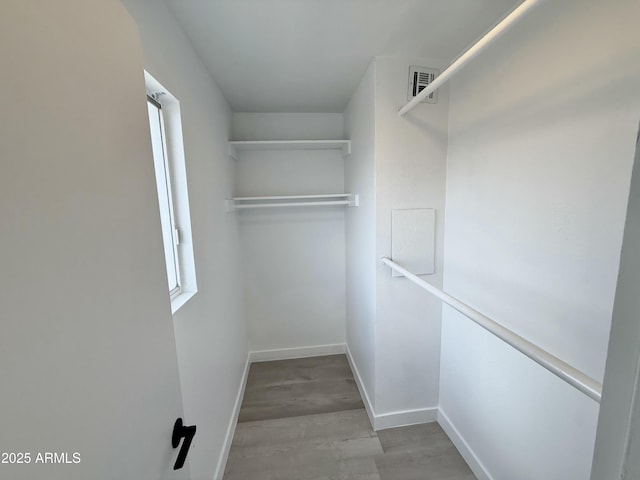 walk in closet with visible vents and wood finished floors