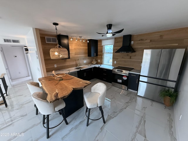 kitchen featuring wooden walls, visible vents, extractor fan, appliances with stainless steel finishes, and marble finish floor