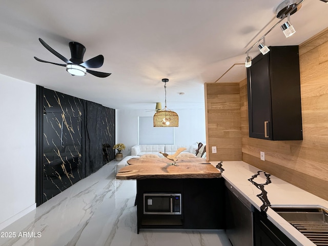 kitchen featuring visible vents, marble finish floor, dark cabinetry, light countertops, and ceiling fan