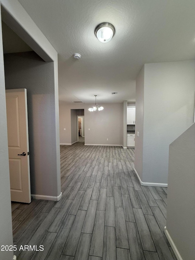 interior space with a notable chandelier and a textured ceiling