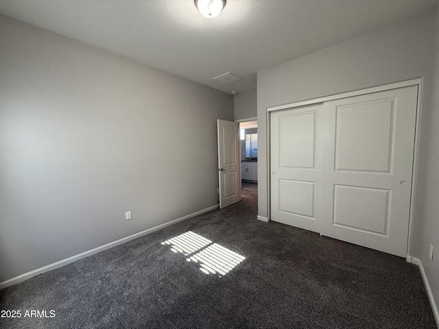 unfurnished bedroom featuring a closet and dark colored carpet