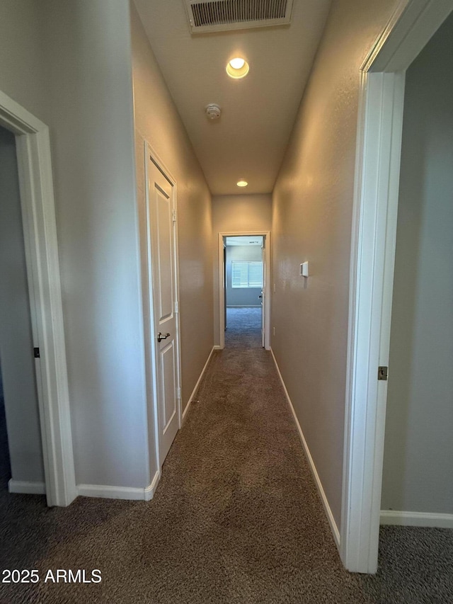 hall featuring dark colored carpet