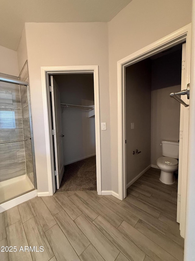 bathroom with toilet and an enclosed shower