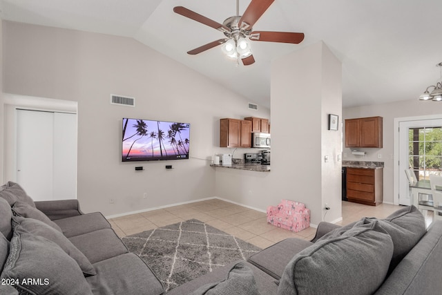 tiled living room with high vaulted ceiling and ceiling fan with notable chandelier