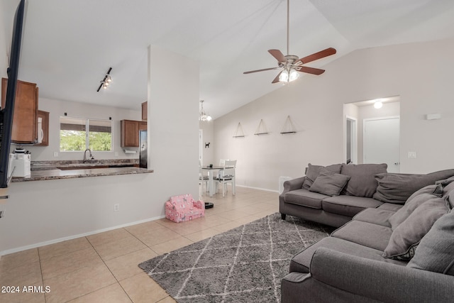 living room featuring ceiling fan, sink, light tile patterned floors, and vaulted ceiling