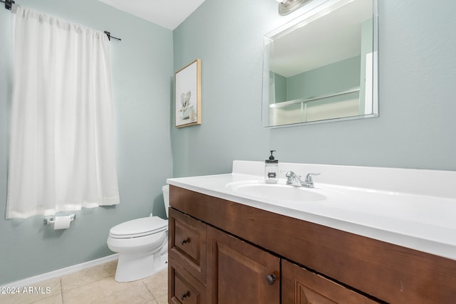 bathroom with toilet, vanity, and tile patterned floors