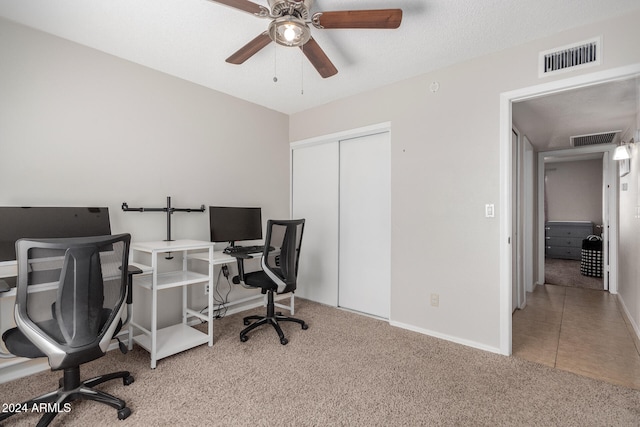 home office with ceiling fan, carpet flooring, and a textured ceiling