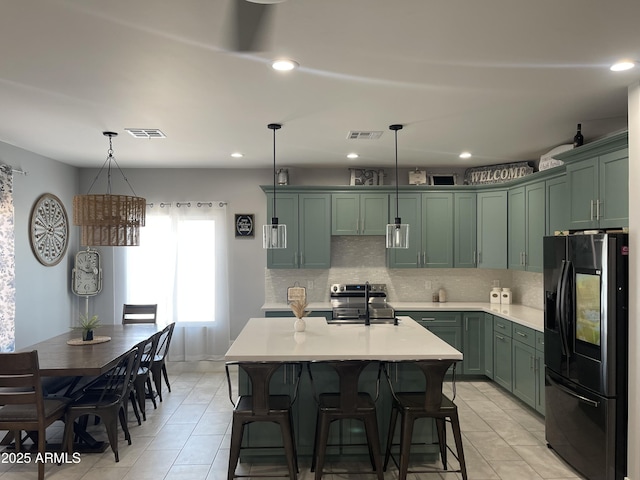 1724 N Main Dr, Apache Junction, AZ 85120 - kitchen with black refrigerator with ice dispenser, green cabinetry, light countertops, decorative backsplash, and decorative light fixtures