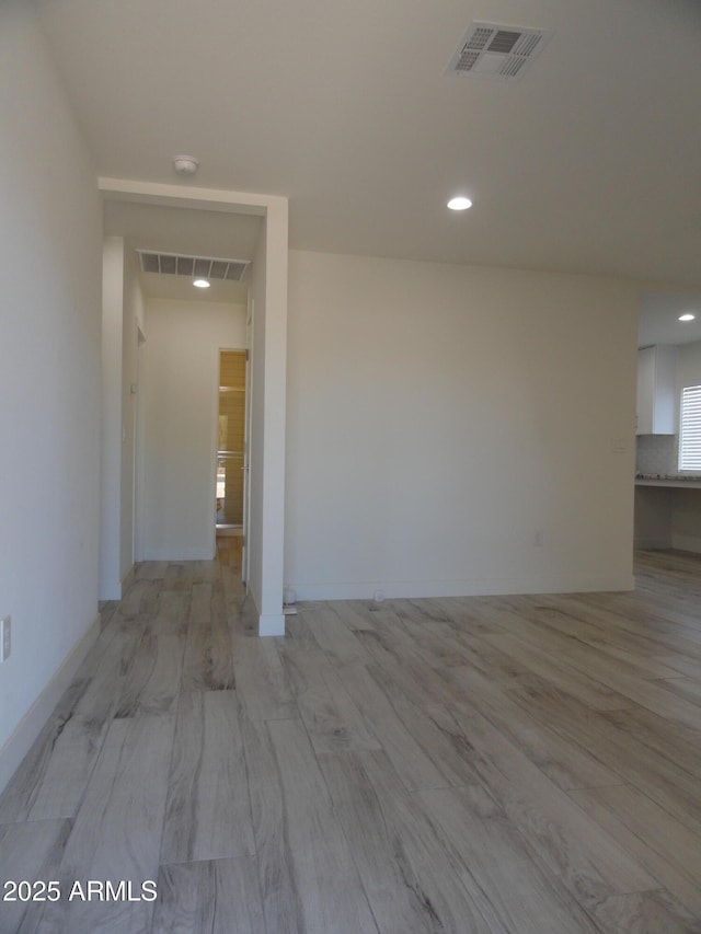 spare room featuring recessed lighting, light wood-style flooring, a smoke detector, and baseboards