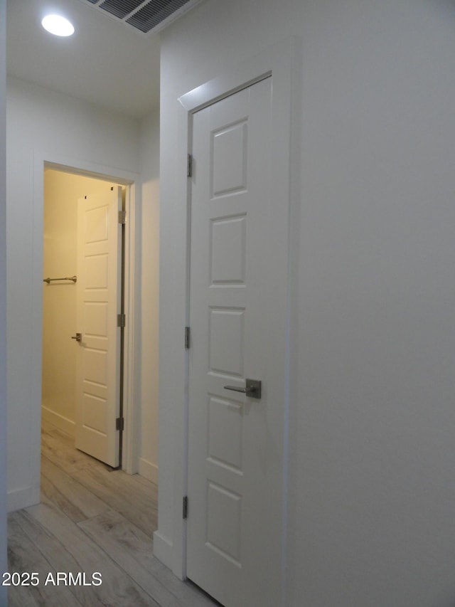 hall featuring light wood-type flooring, recessed lighting, and baseboards