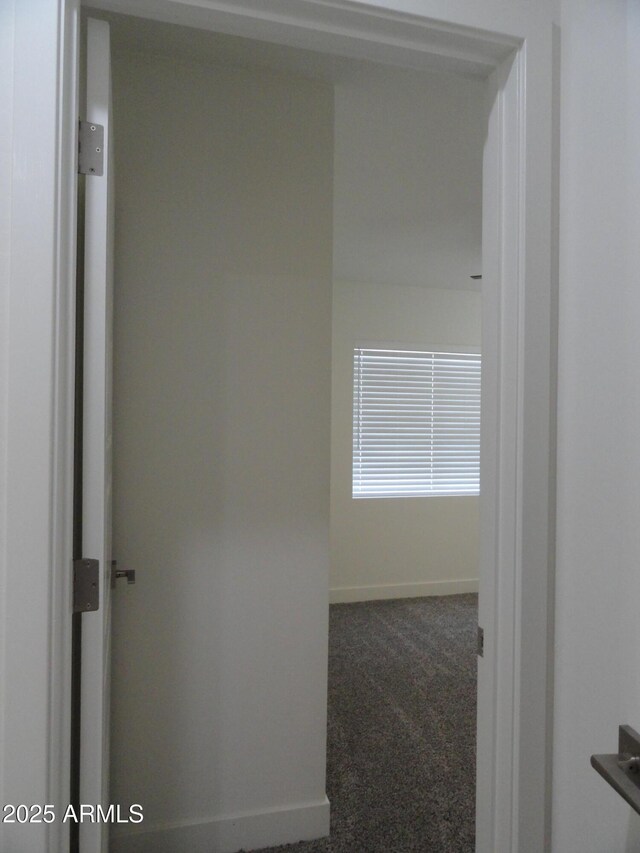 corridor featuring carpet floors and baseboards